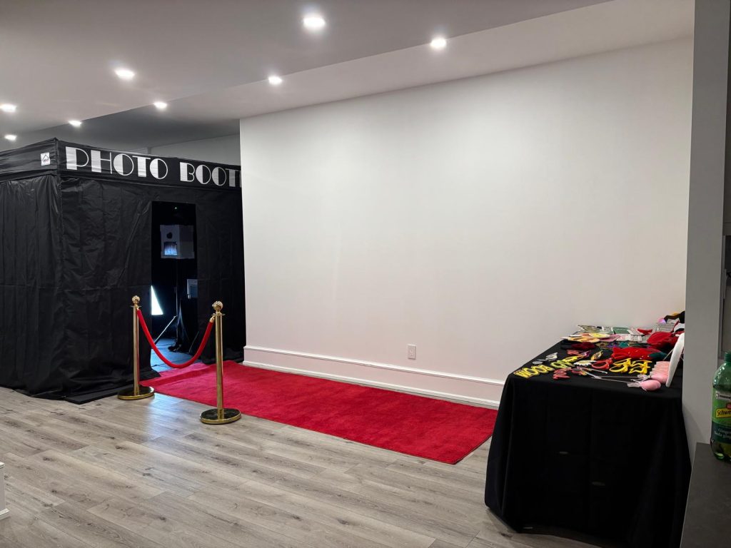 Enclosed photo booth rental with props, a red carpet and stanchions