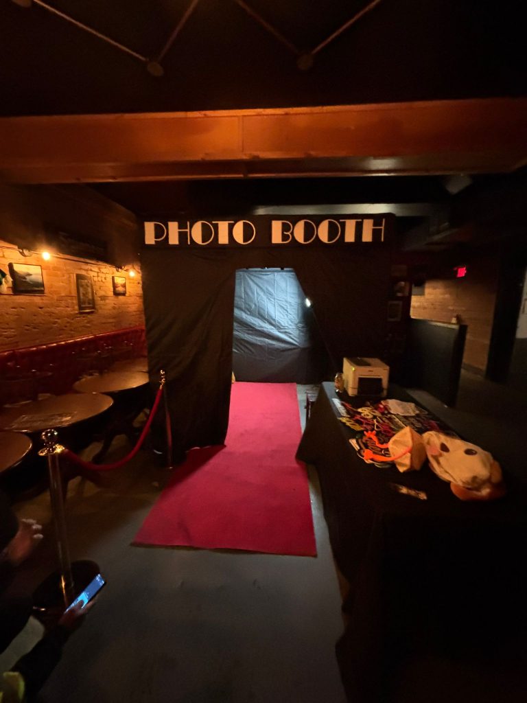 Party rentals in Cambridge. An enclosed photo booth with a red carpet, stanchions and props
