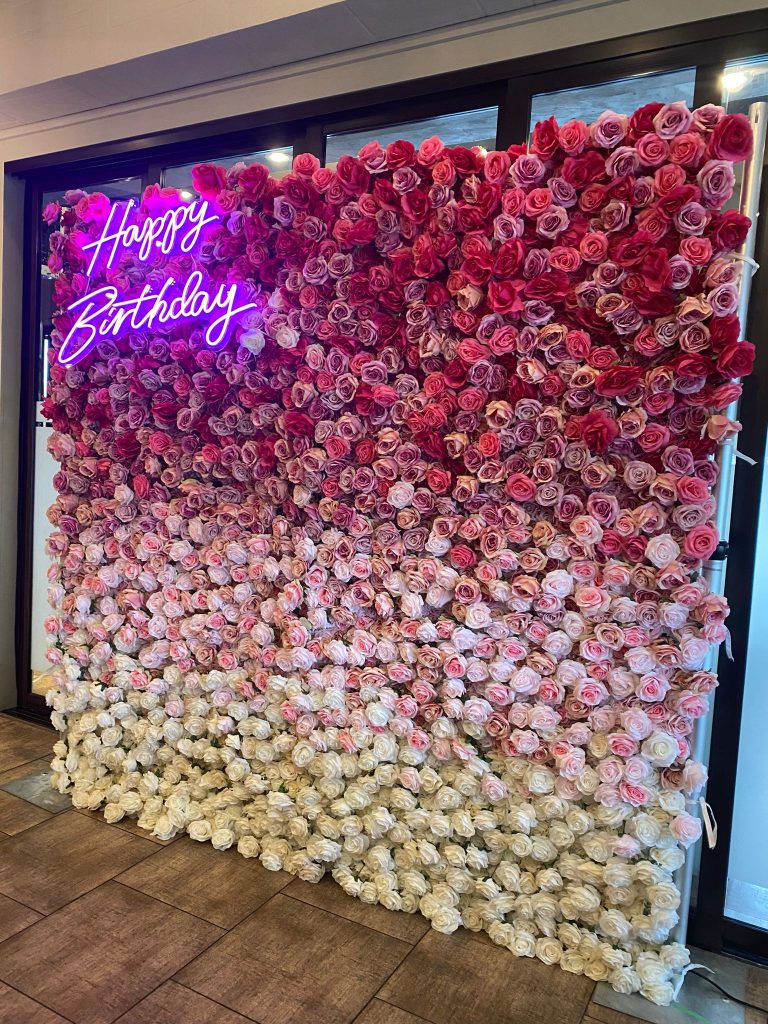 London flower wall with a happy birthday neon sign